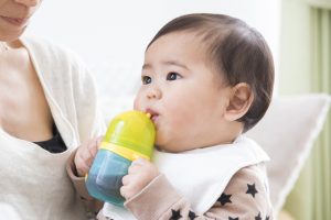 ベビーマグでお茶を飲む赤ちゃん