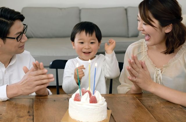誕生日ケーキを食べる親子