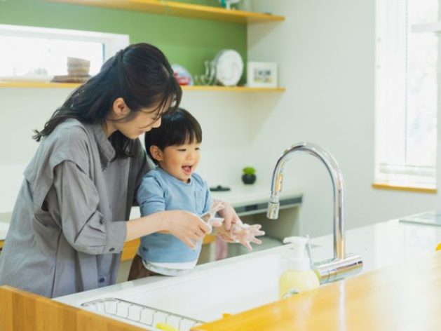 キッチンで手洗いする男の子とお母さん