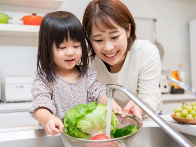 キッチンで野菜を洗うお母さんと女の子